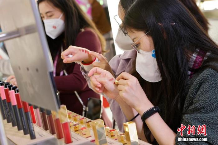 圖為女生正在體驗口紅產(chǎn)品。 殷立勤 攝