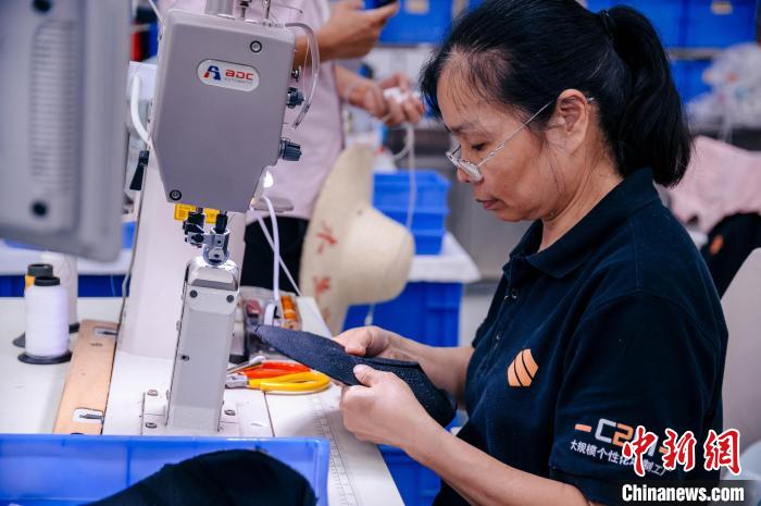 圖為員工在生產(chǎn)線工作?！±钅宪?攝