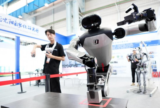 9月5日，在沈陽的2025全球工業(yè)互聯(lián)網(wǎng)大會的展覽區(qū)現(xiàn)場，中國科學(xué)院沈陽自動化研究所的機(jī)器人工程師在調(diào)試具身智能操作系統(tǒng)。新華社記者 李鋼 攝