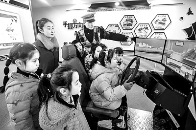 山東省榮成市公安局道路交通安全宣傳教育基地，交警帶領小學生現(xiàn)場體驗模擬駕駛。新華社發(fā)